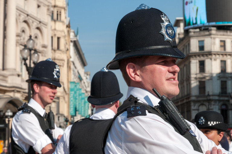 Four Metropolitan Police officers stand on duty in Central London.