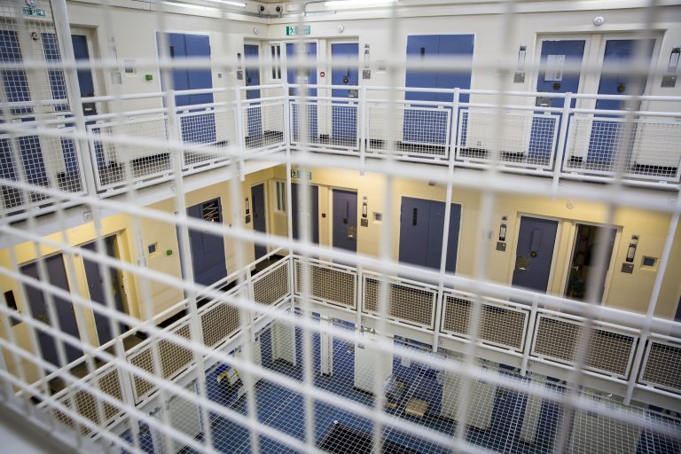 A view of the cell doors on different levels through the wire fencing inside a wing at HMP Featherstone, Wolverhampton, Staffordshire United Kingdom. HMP Featherstone is a Category C adult male training prison with a population of around 700 and operated by HM Prison Services. (Picture credit: © Andy Aitchison)