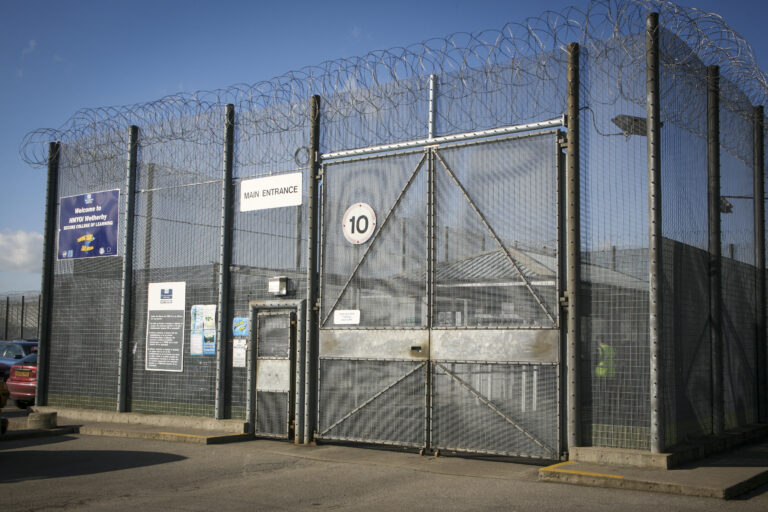 A metal gate with barbed wire.